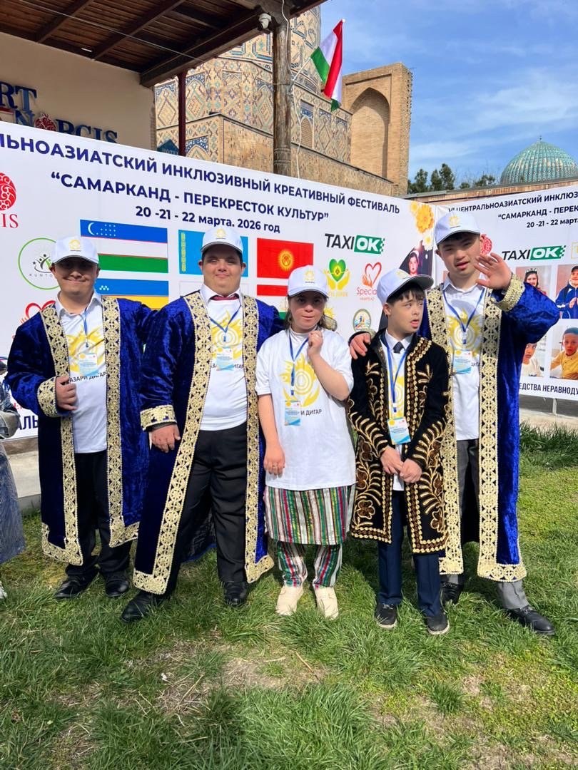 Five young people with Down syndrome in traditional robes and Nazari Digar shirts at an inclusive festival in Samarkand